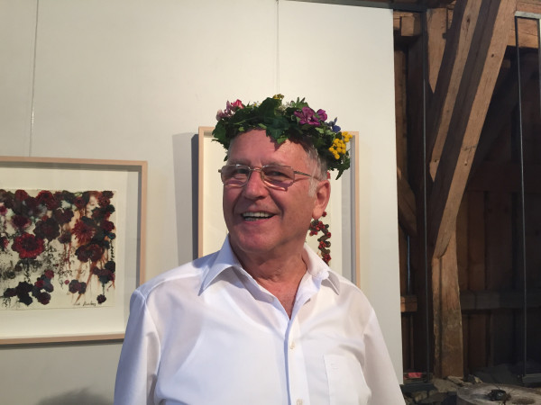 Achim Lerche mit Blumenkranz von Gertrude Lang zum 25. Jubiläum der Galerie im Woferlhof 2015